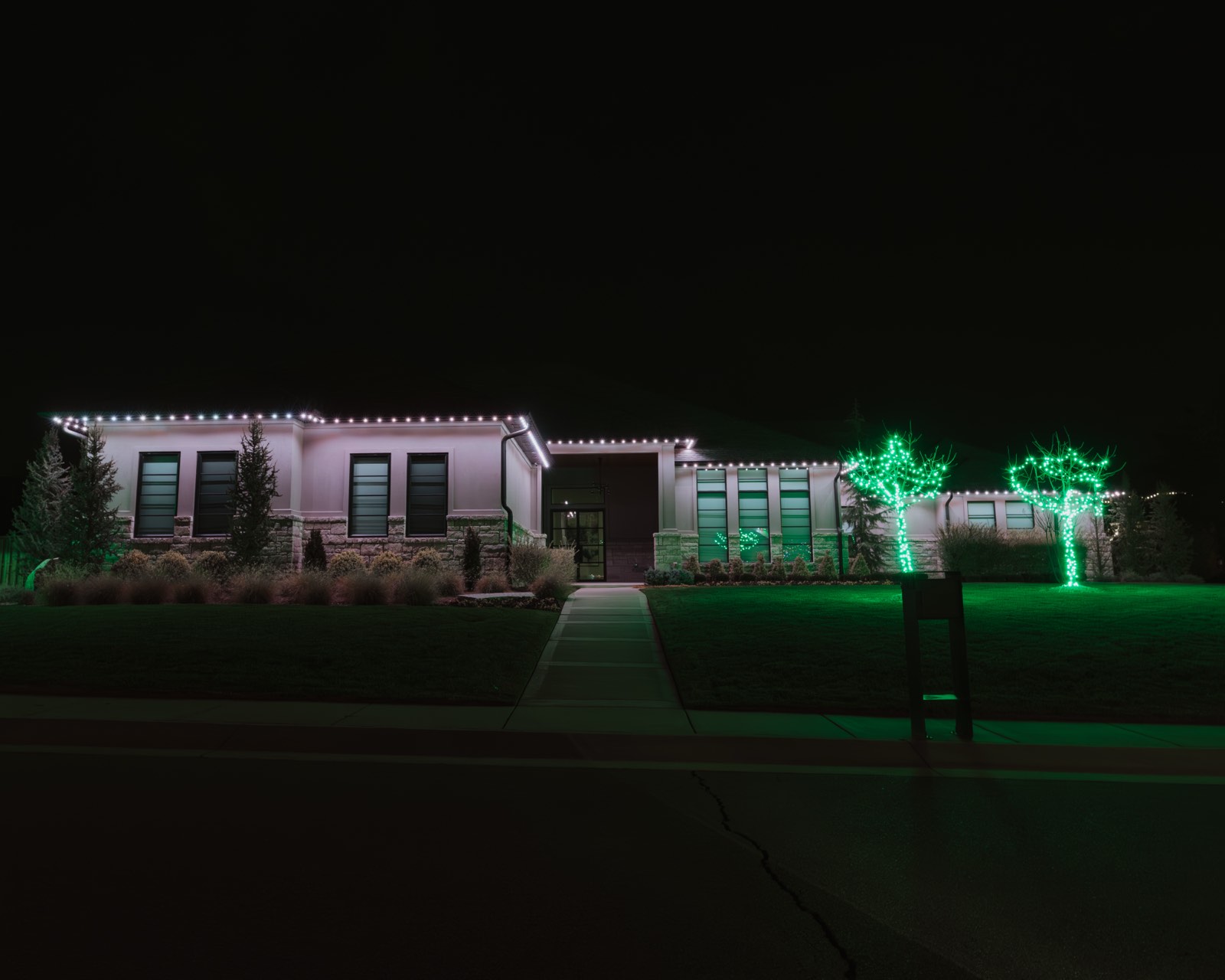 Bright white permanent security lighting across a home perimeter